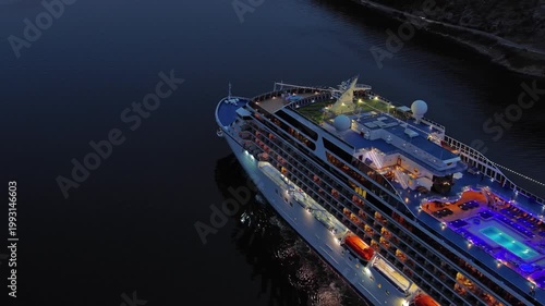 Aerial view of illuminated large cruise ship in the sea at night, 4k