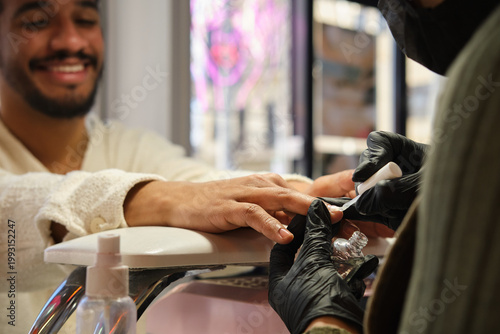 Tableau sur toile close up shot of Hispanic man enjoying a manicure beauty treatment in salon