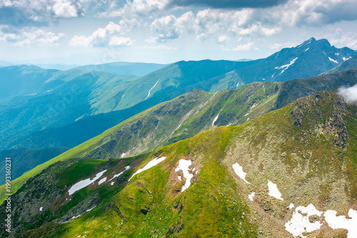 romania mountain scenery in summer. gorgeous mountainous landscape of carpathians. background with rocky cliffs and grassy hillsides under a cloudy sky. fagaras ridge of southern carpathian mountains