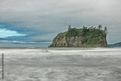 Long exposure waves washing over the rocky Olympic National Park coastline beneath dramatic Pacific Northwest clouds
