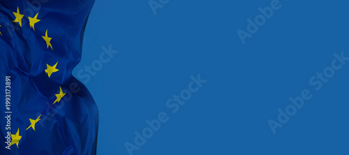 Tableau sur toile Drapeau de l’Union européenne flottant sur fond bleu, symbolisant l’unité, la coopération et les valeurs communes du continent européen, pouvant servir d'arrière-plan