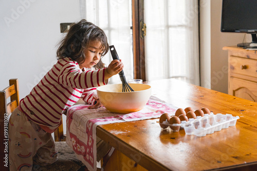 littl toddler girl baking at home in the kitchen with flour, concept activity with children, cooking together with complicity