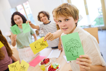 School children displaying healthy food drawings in a creative classroom activity