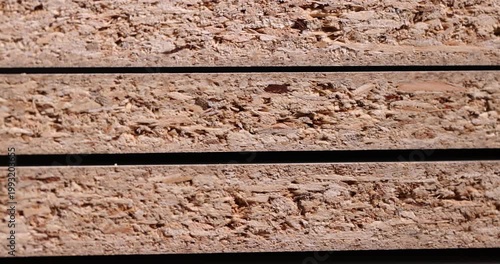 The chipboard material is stacked, a composite material made of wood with a porous edge and a multilayer structure in side lighting with a clear contour and an organic surface.