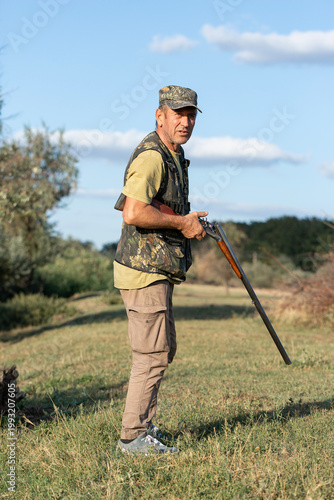 The hunter reloads his gun and prepares to shoot at game