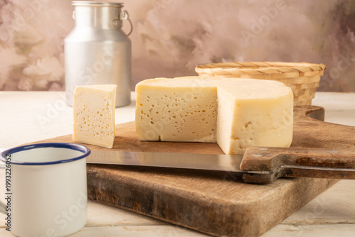 Semi-cured cheese, a table with semi-cured cheese and accessories in the interior of Brazil, selective focus.