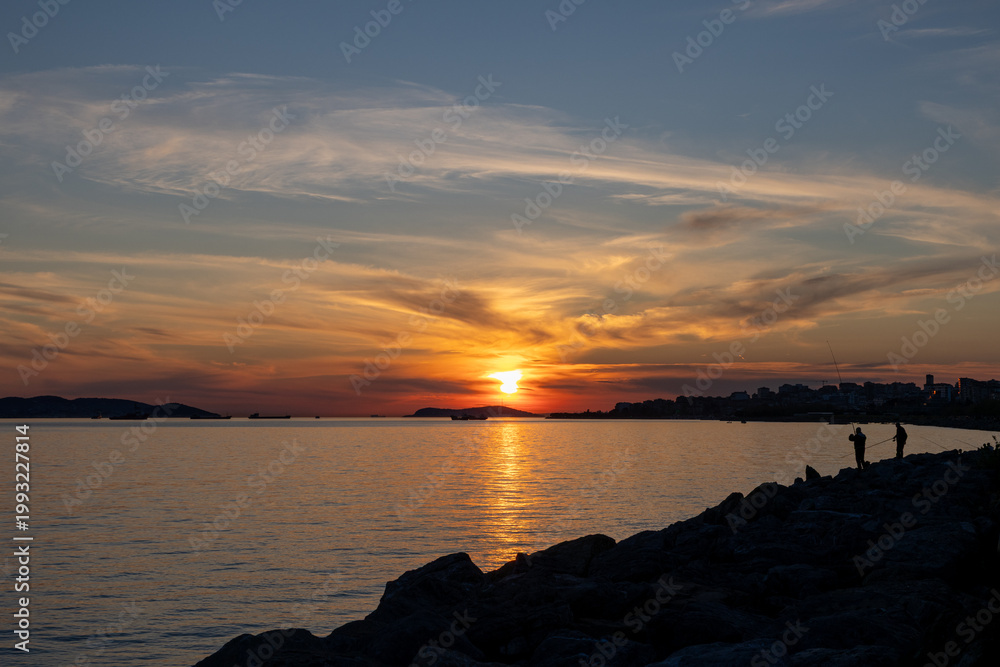 Obraz premium Istanbul Kartal Coast Sunset with Fishermen Silhouettes, Sea of Marmara and Princes Islands, Turkey