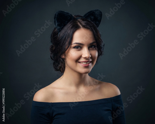 Attractive woman wearing cat ears on black background