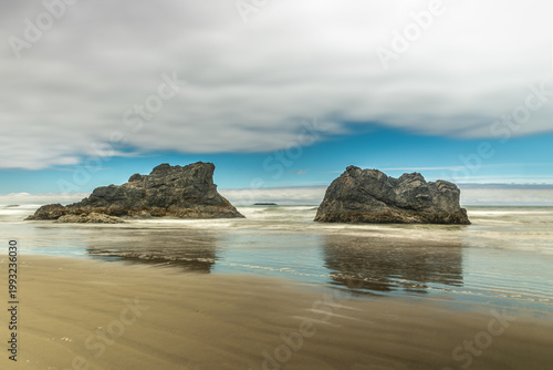 Long‑exposure reflections of rugged sea stacks along the dramatic Olympic National Park coastline in Washington State