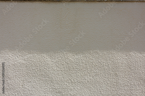 Canvas Print Sunlight hits lower half of neutral toned wall with knockdown stucco finish, creating neutral two-tone surface divided by soft horizontal shadow darkening its off-white coating to subtle beige hue