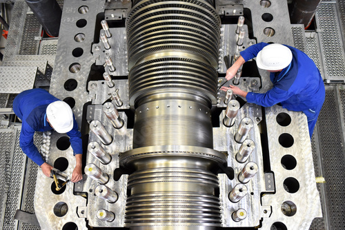 workers assembling and quality control of gas turbines in a modern industrial factory - checking dimensions with a measuring device