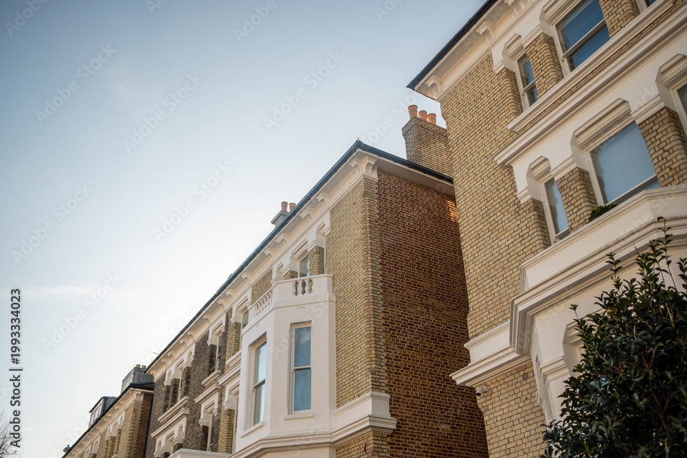 Fototapeta premium LONDON - Low angle view of elegant Victorian terraced houses in Earls Court with blue sky copy space