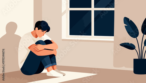 Young man sits alone, hugging knees