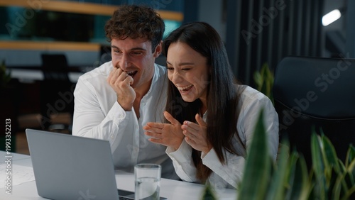 Tableau sur toile Happy two Caucasian workers business colleagues winning with laptop yelling cele
