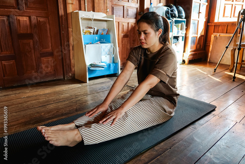 Asian Woman Stretching Legs on Yoga Mat at Home Indoor Workout