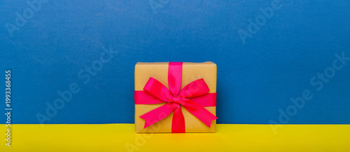 holiday paper present tied pink ribbon bow top view with copy space. Flat lay holiday background. Birthday or christmas present. Christmas gift box concept with copy space