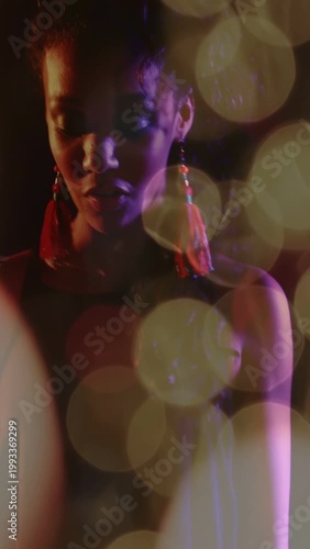 Vertical video: Musician pressing keys and singing on stage bokeh orbs drifting highlighting face