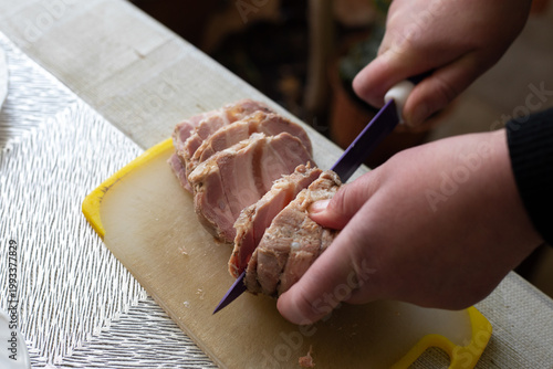 Woman cutting ham on the table. Selective focus.
