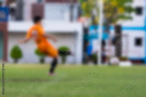 Blurred background of Thai boy kicked football