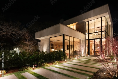 Modern Home Exterior at Night With Lights Illuminating the Pathway and Garden