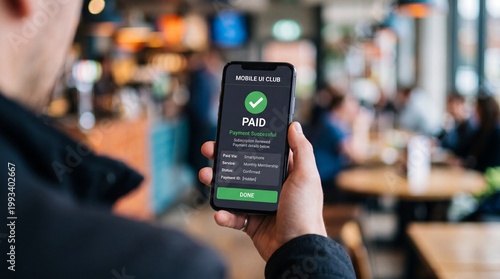 A person holding a smartphone displaying a successful checkmark on a green background, amidst a vibrant café atmosphere