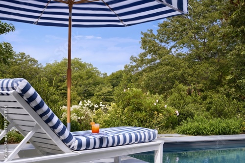 Sunny Day by the Pool With Striped Lounge Chair and Drink Under Umbrella