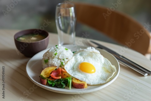 Breakfast Plate With Rice, Vegetables, and an Egg Served in a Dining Setting