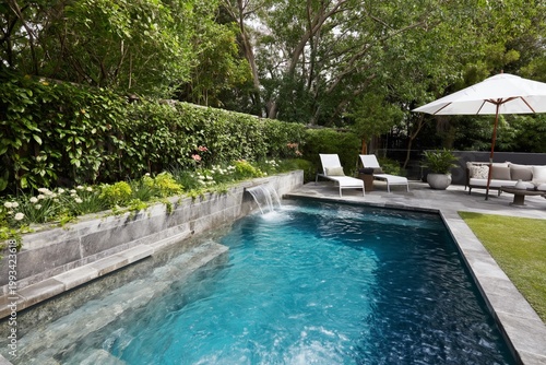 Private Backyard With Pool and Lounge Area in Evening Light Near Tall Trees a...