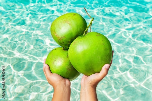 Bright Green Coconuts Held Above Water Surface on a Sunny Day in a Pool