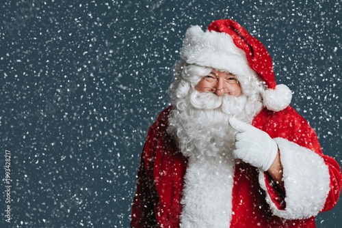 Santa Claus Smiles and Points While Snow Falls in a Festive Setting During th...