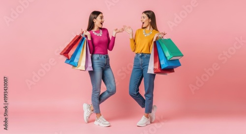 Joyful twin sisters enjoying colorful shopping spree with matching outfits, stylish accessories, and vibrant paper bags against a playful pastel pink studio background

