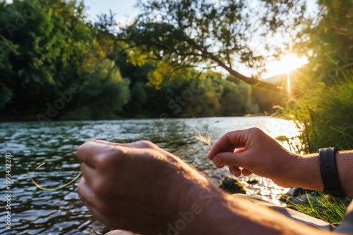 Hands Hold Grass by the River During Sunset in Nature at a Calm Location