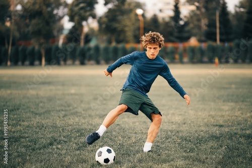 Boy Kicks Soccer Ball on Grassy Field During Afternoon Practice With Friends ...
