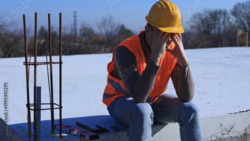 Construction worker having a depressed period, headache, issues on a construction site outdoors.