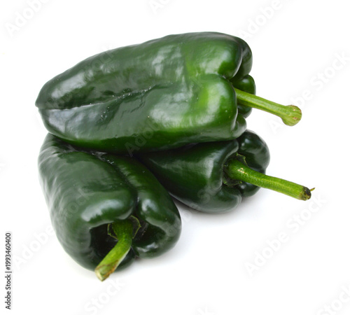 Stack dark green poblano peppers isolated on white