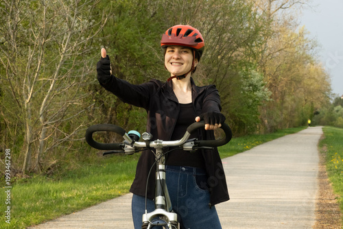 Wallpaper Mural Happy woman cyclist showing thumbs up gesture while riding Torontodigital.ca