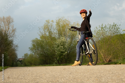 Wallpaper Mural Happy woman cyclist showing thumbs up gesture while riding Torontodigital.ca