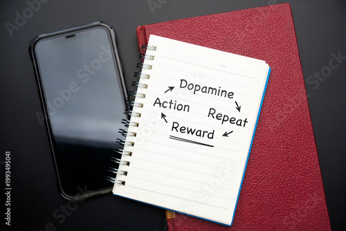 Photos Dopamine reward loop concept with smartphone and habit cycle notes