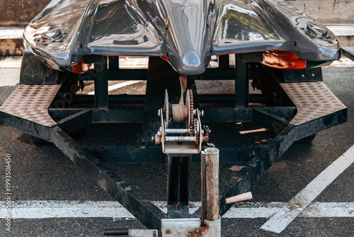 Manual Hand Winch on Boat Trailer with Strap and Rusty Details. Close up of Mechanical Winch Mechanism for Boat Transport and Hauling. Metal Boat Trailer Frame with Manual Crank Winch Equipment.