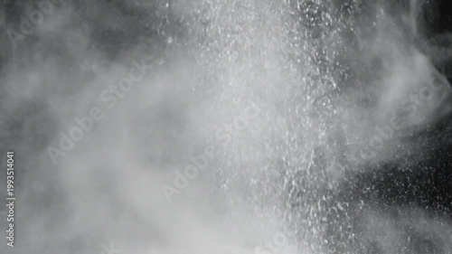 Explosion of white particles against a dark background, evoking a sense of dynamic motion and abstract energy in a dramatic, high-contrast composition
