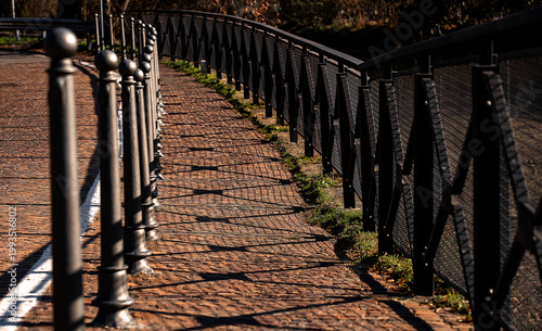 geometric patterns created on the cobblestones by the shadows of a railing