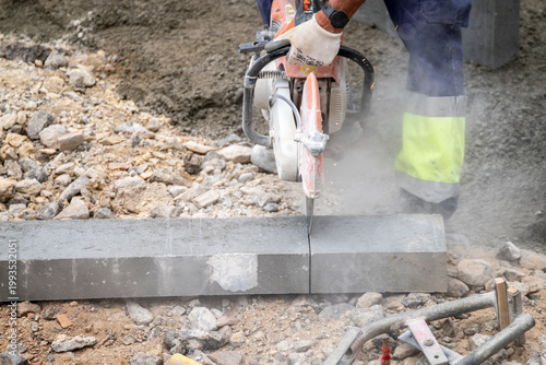 Foto Worker cutting concrete curb with power saw The Concept of industrial power and