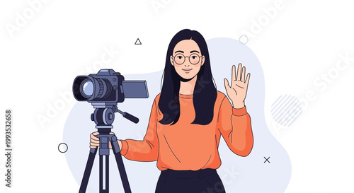 Young woman with glasses and orange sweater filming with a professional camera on a tripod, waving hello