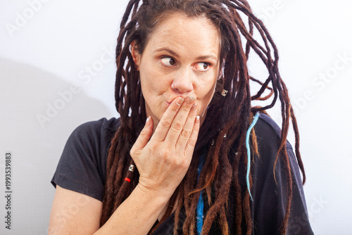 Surprised woman covering mouth reacting to unexpected news