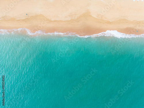 Bild auf Leinwand Aerial overhead view capturing the relaxing scene of blue ocean water gently washing onto a golden sand shore