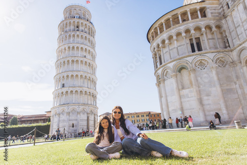 фотографія Mother and daughter relaxing on grass, enjoying family vacation at Leaning Tower