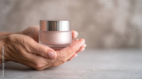 Hands holding a cosmetic cream jar on a textured surface background