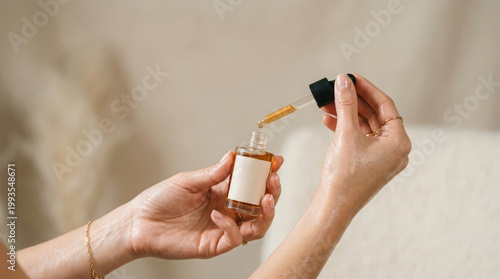 Woman applying facial oil from dropper bottle in bright indoor setting