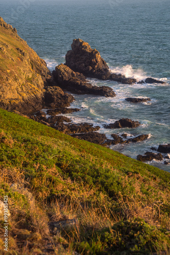 Scenic coastal landscape of Guernsey with lush greeney overlooking turquoise Atlantic ocean.