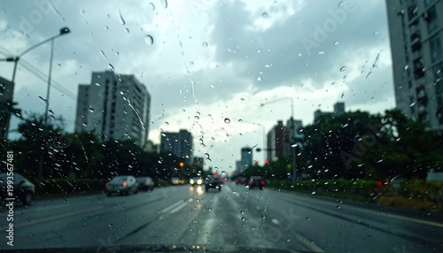 Rainy Urban Drive with Raindrops on Windshield in Cityscape